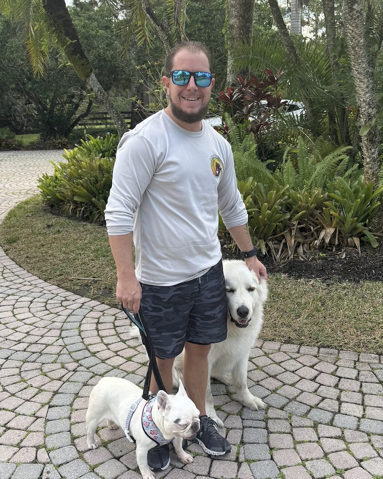 Scott, founder and head trainer of Florida's Finest K9, with two dogs on a leash